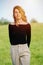 Sunlit portrait of a beautiful woman in her thirties over a grass field