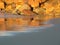 Sunlit rocks on sandy beach