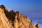 Sunlit rocks and sea in clouds at evening