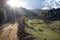 Sunlit rural road in mountain landscape.