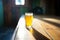 sunlit saison beer glass casting a shadow on a wooden table