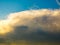 Sunlit thundercloud like surf wave in blue sky