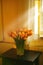 Sunlit tulips on the sidetable. Tulip arrangement standing on a sidetable in front of a window.
