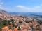 Sunlit view of the city of funchal from above with rooftops and buildings in front of a bright blue sea