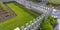 Sunlit yard with lawn white fence and shrubs