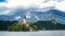 Sunning panoramic view of The island of Bled, Bled castle on cliff, Julian Alps and Church of the Assumption,Bled, Slovenia.