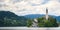 Sunning panoramic view of The island of Bled, Bled castle on cliff, Julian Alps and Church of the Assumption,Bled, Slovenia.