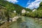 Sunny alpine village and clear mountain stream