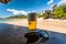 Sunny beach, beer and sunglasses on wooden bar table. Ocean view with fresh beer on natural background