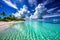 A sunny beach with crystal blue water and white clouds in the sky