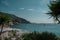 Sunny beach with palm trees and sun parasols in a lagoon