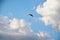 Sunny bright blue sky background with white clouds in summer. Paragliding extreme sport in the rural mountain area. Lonely