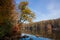 Sunny and cold October morning on a forest lake, clear blue sky with tree reflections in the still water surface