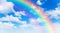 Sunny day background with rainbow, blue sky with white cumulus clouds