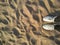 Sunny day. On the beach beige sand white tourist sneakers