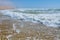 Sunny day on the beach.  Blue waves breaking on the shore.