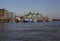 Sunny day, blue skies and shiny waters of the river Thames; buildings on the bank.