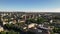 Sunny day cityscape flight. Small town aerial view with cars, houses and clear blue sky. Colorful panorama with