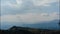 Sunny day with clouds. Timelapse. Light white clouds fly across bright blue sky near small rocks.