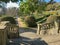 Sunny day in formal garden with topiary plants, smooth lines, geometric shape, raunded stairs and tracks in Lisbon