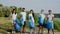 On a sunny day in front of the camera beside a big lake on the beach group of multiethnic volunteers posing in front of