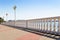 Sunny day on Gelendzhik resort city promenade. White stone balustrade with round lanterns in frame. View on sea bay.