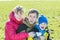 Sunny day outdoor family portrait of three cheerful people in park