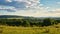 A sunny day in the Saarland with a view over meadows into the valley