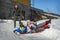 On a sunny day in winter, a family plays on the hill. A father pushes his daughter and son down the mountain to go sledding