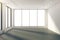 Sunny empty room with windows in floor and white walls