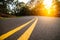 Sunny forest asphalt road curve with marking lines at sunset time.