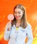 Sunny happy smiling woman with sweet caramel lollipop over colorful background