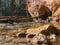 Sunny landscape with sandstone cliff on river bank, fast flowing river water