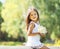 Sunny little girl with a bouquet of chamomiles flowers in spring