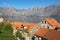 Sunny Mediterranean landscape. Montenegro, Adriatic Sea. View of Bay of Kotor and red roofs of Prcanj town