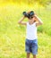 Sunny photo child boy looks in binoculars outdoors in summer