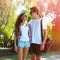 Sunny portrait of happy young couple teenagers in urban style