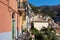 Sunny promenade along color houses of Riomaggiore town, Italy