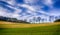 Sunny rural idyllic landscape winter scene  with hills, grass, trees, forest, blue sky, clouds, contrails,