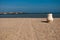 Sunny sand beach with jug and two tracks. Ceramic pot in sand on beach. Blue ocean and white jug on beach