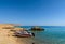 Sunny sand beach and stones on island Tiran in Egypt, Red sea, blue sea with yachts