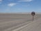 Sunny scenery of a desert road with a speed limit signpost in Skeleton Coast, Namibia, Africa