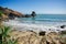 Sunny seascape. A small bay with palm trees and rocks in the water