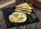 sunny side up egg with sliced bread served in a dish isolated on cutting board side view of breakfast on wooden background