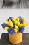 Sunny spring morning. Bunch of blue hyacinths and yellow tulips on wooden table. Present for a girl. Flowers bouquet in