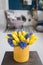 Sunny spring morning. Bunch of blue hyacinths and yellow tulips on wooden table. Present for a girl. Flowers bouquet in