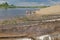 A sunny summer day on the beach, a wild village beach, sand, people, trees in the foreground