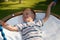 On a sunny summer day, a boy swings on a swing in a playground in a public park