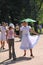 Sunny summer day in the city Park. girls public entertainers dancing with the tourists people under the music of a military brass