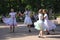 Sunny summer day in the city Park. girls public entertainers dancing with the tourists people under the music of a military brass